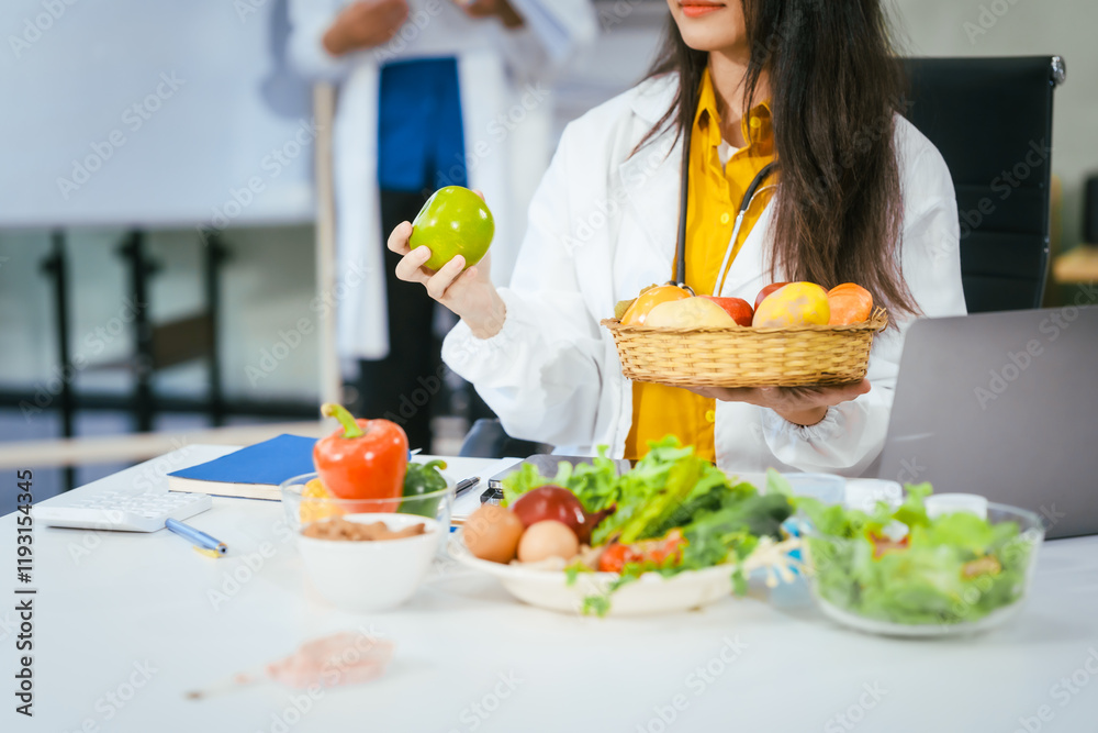 Two nutritionists,female and male, work in a hospital, analyzing vegetable and fruit salads, offering online advice, helping patients embrace clean eating habits and weight control for better health