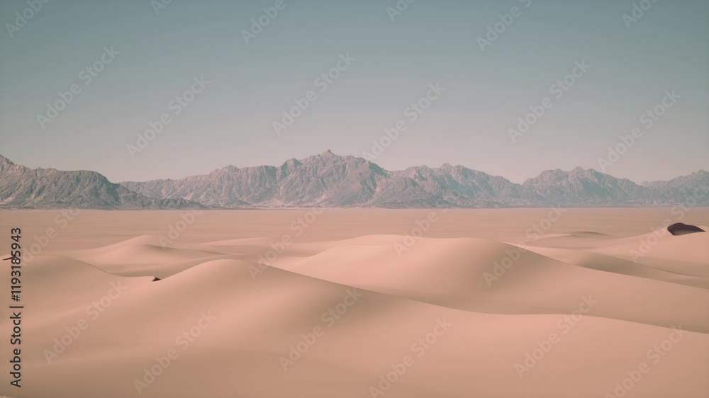 Barren desert terrain with towering mountains in the background under a clear sky.