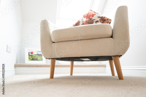 Carpet level view off a single fabric chair seen in a first floor bedroom of a new show home. A skylight window can be seen which lets in a lot of natural light.