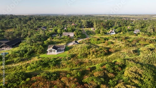 Aerial view of holiday homes in Lodbjerg Hede, Denmark, nestled in heathland landscapes with lush greenery near North Sea. photo