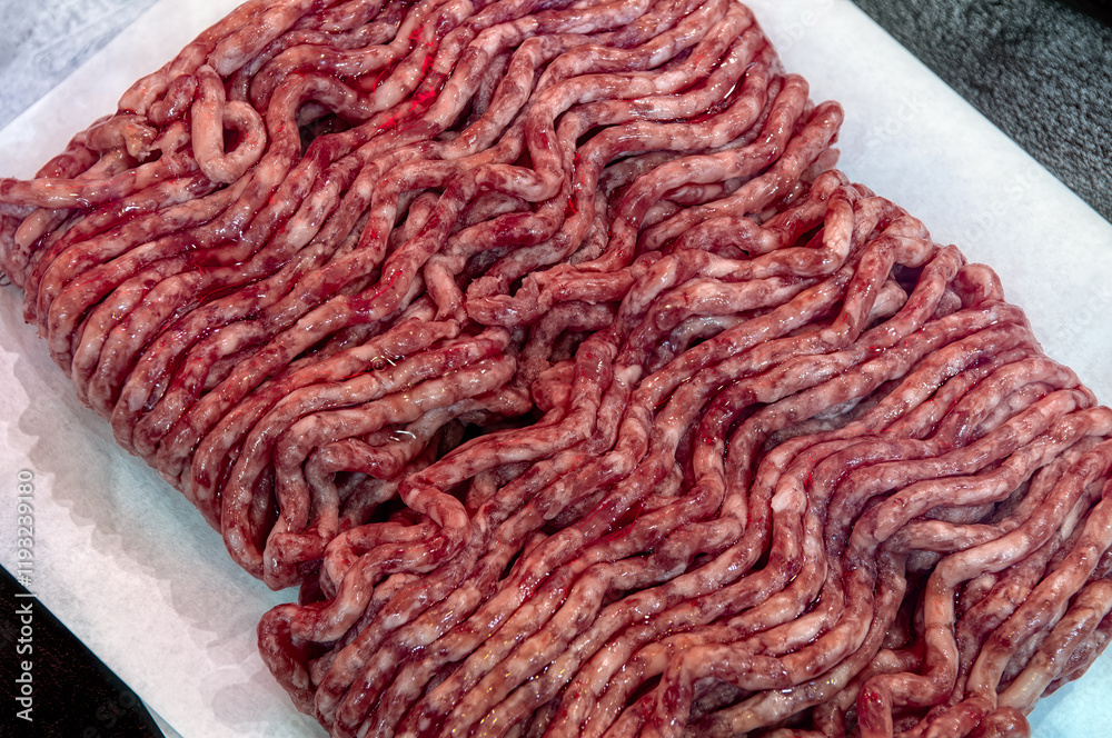 Fresh raw minced meat on paper, pork, beef, forcemeat close-up isolated on white background, top view. Fresh raw minced meat on paper, pork, beef, forcemeat close-up isolated on white background, top view.