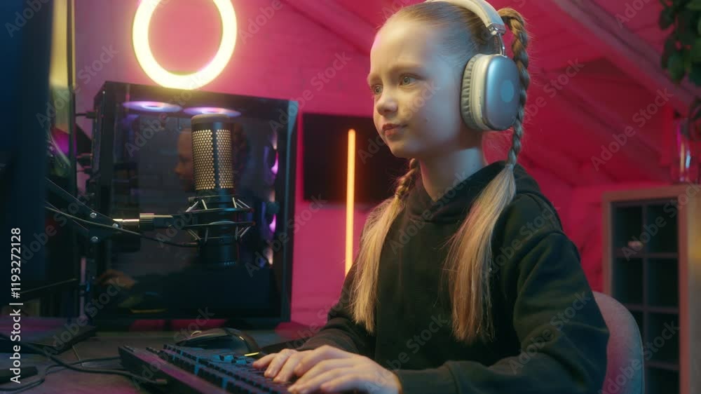 Little girl focused concentrated worried anxiety daughter child kid playing computer video game typing keyboard online gaming addicted failure lost difficult talking microphone stream neon light gamer