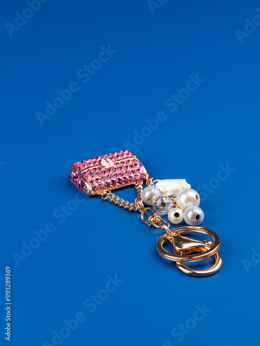 close up of beautiful shiny pink  rhinestone handbag keychain on  blue background photo