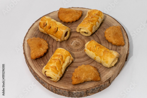 Assorted savory snacks on a rustic wooden board, ready to eat. A delicious variety of appetizers perfect for parties, catering, or food styling concepts. photo