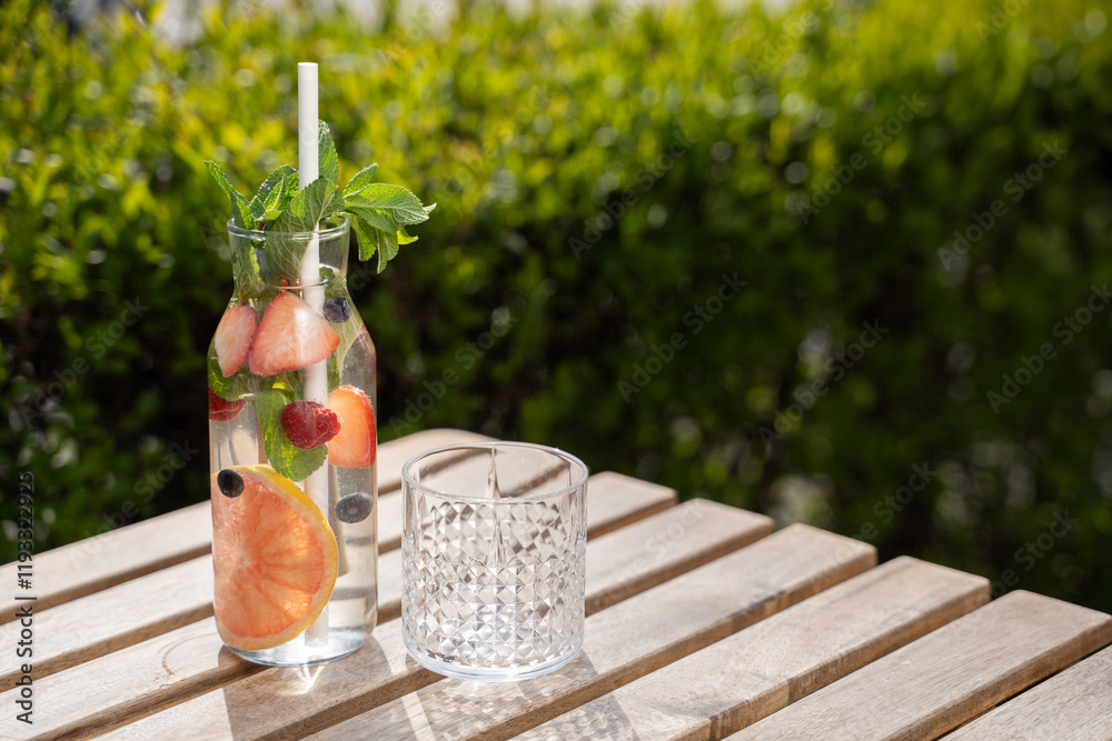 bottle carafe of fresh fruit water lemonade drink on sunny terrace garden bar restaurant