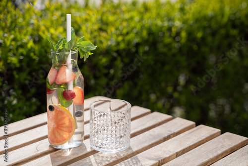 Obraz na płótnie bottle carafe of fresh fruit water lemonade drink on sunny terrace garden bar restaurant w salonie