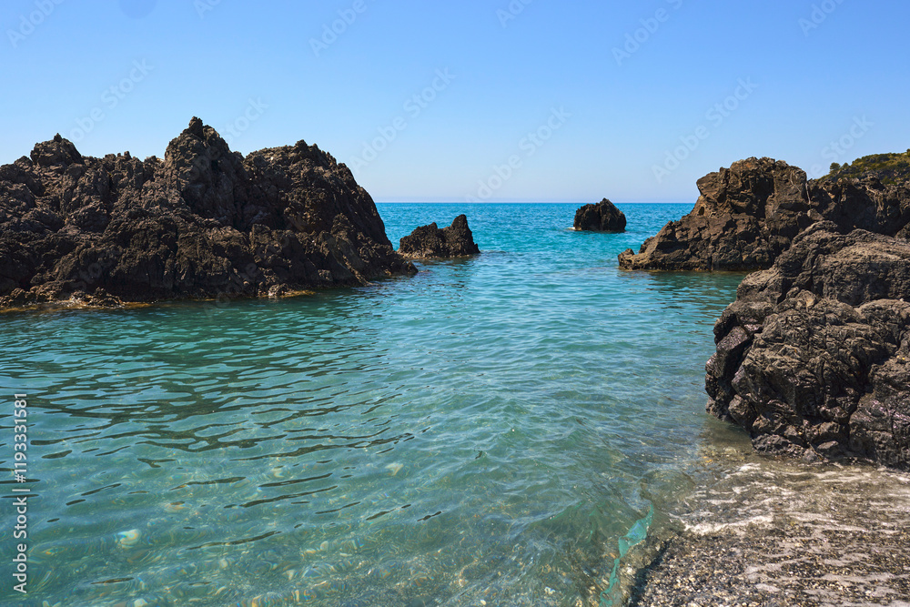 Clear water with rocks and blue skies in the backdrop Clear water with rocks and blue skies in the backdrop