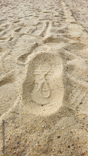Closeup Shoe Print on the Sand at the Beach, mark left by a shoe on the surface of the sand. 