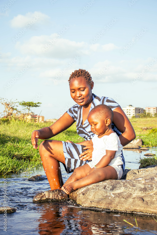 A beautiful young African woman playing outdoors with her baby boy at sunset A beautiful young African woman playing outdoors with her baby boy at sunset