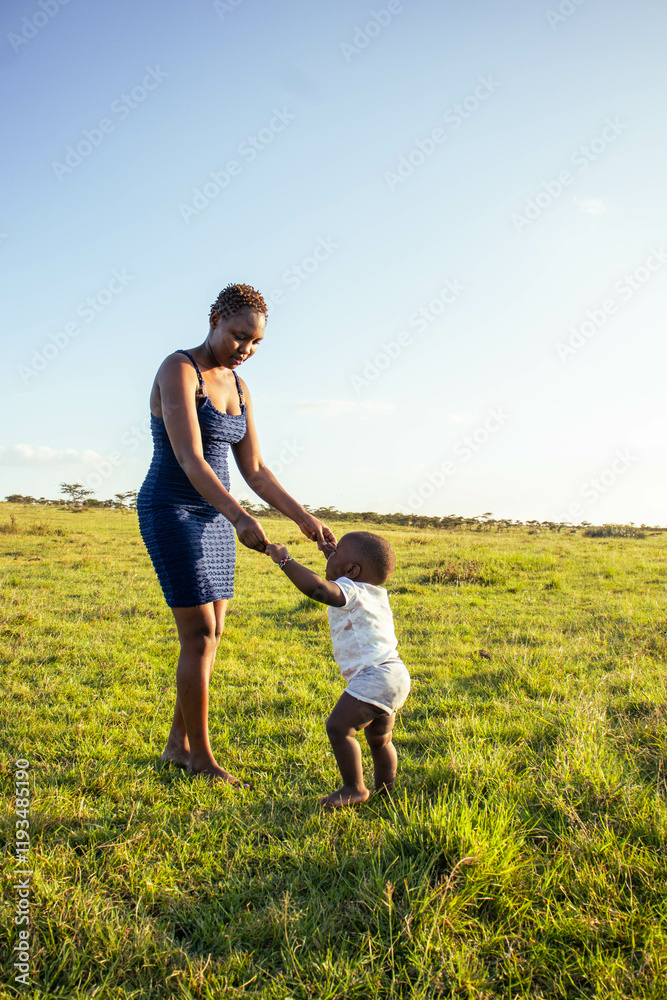A beautiful young African woman playing with her baby boy outdoors at sunset A beautiful young African woman playing with her baby boy outdoors at sunset