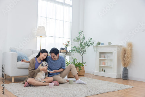 Asian couple spends quality time with their pug dog in their living room