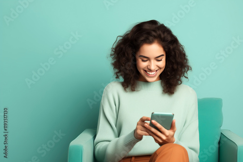 happy girl with smartphone sitting on armchair, turquoise color tones