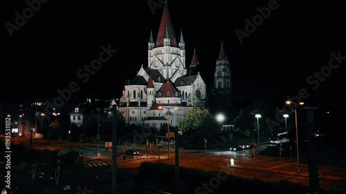 Wien Austria St Francis of Assisi Church illuminated at night. Showcasing neo Romanesque architecture, historic landmark religious site. Tourism travel European cityscape urban lights spirituality  photo