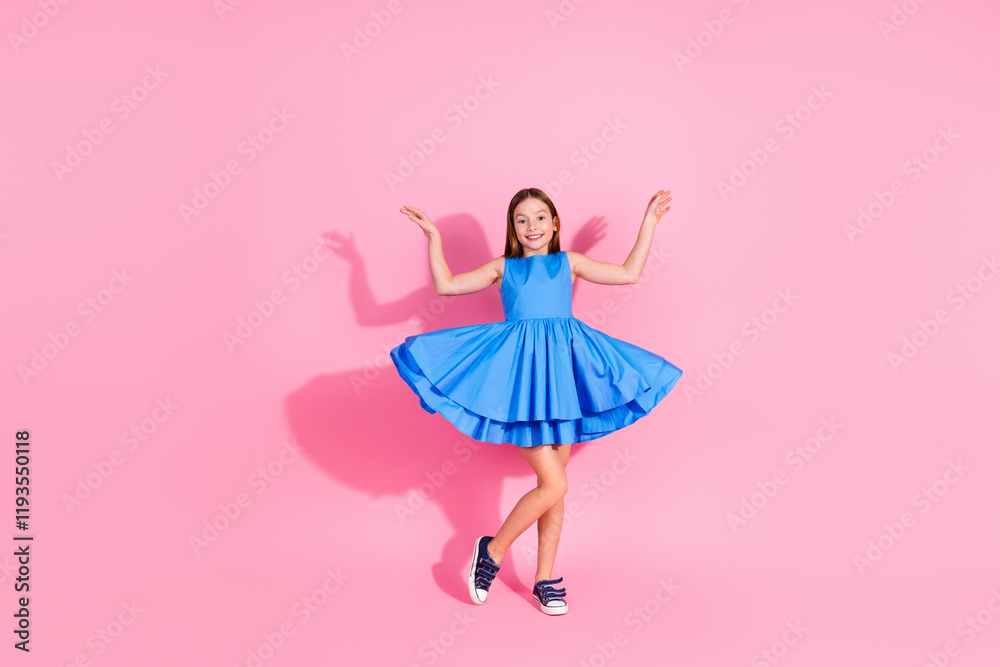 Charming young girl in stylish blue dress posing against pink background celebrating vibrant youth Charming young girl in stylish blue dress posing against pink background celebrating vibrant youth