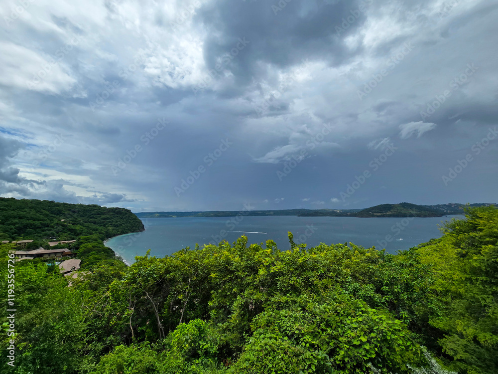 Obraz premium Blanca Beach and the blue waters of Culebra Bay, lush green trees, blue sky and clouds in Liberia Guanacaste Costa Rica