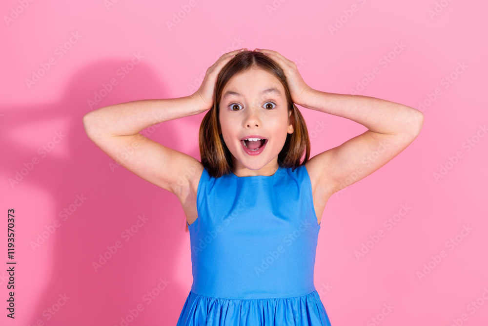 Cheerful young girl in a blue dress posing excitedly against a pink background Cheerful young girl in a blue dress posing excitedly against a pink background