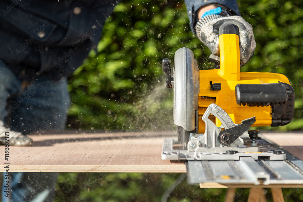 Male using electric circular saw to cut DIY sheet material outside Male using electric circular saw to cut DIY sheet material outside