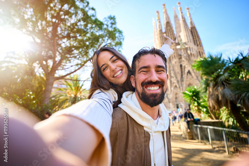 Принти на полотні Young mixed race couple taking a selfie in front of Sagrada Familia in Barcelona