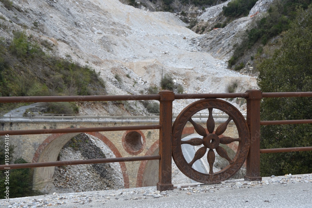 Fototapeta premium Historic stone bridge with artistic railing in a rocky landscape