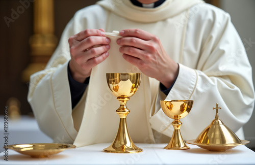 Christian priest prepares sacred items for consecration liturgy in church. Priest wears white robe, delicately arranges sacred vessels. Gold chalice, paten ready for symbolic ritual. Religious