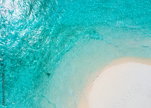 from above tropical beach with light blue water and light sand photo