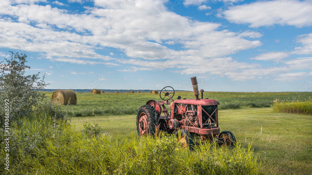 Fototapeta premium Old red tractor left in a Saskatchewan field.