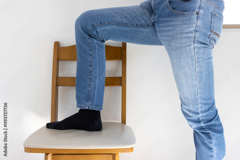 椅子に登ろうとしている男性の脚(日本人、30代、顔無し)