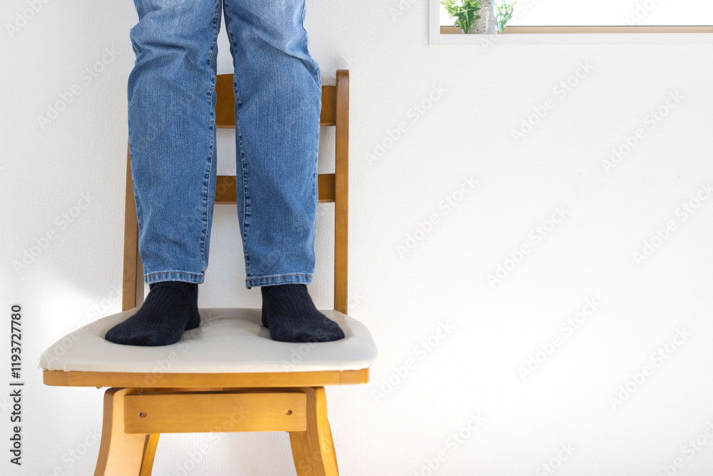 椅子の上に立っている男性の脚(日本人、30代、顔無し)