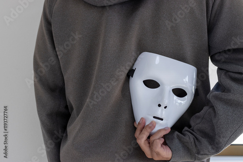 白い仮面を背中に隠す男性（日本人、30代、顔無し）