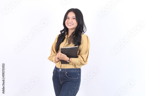 Woman is smiling and holding a book. Business asian woman