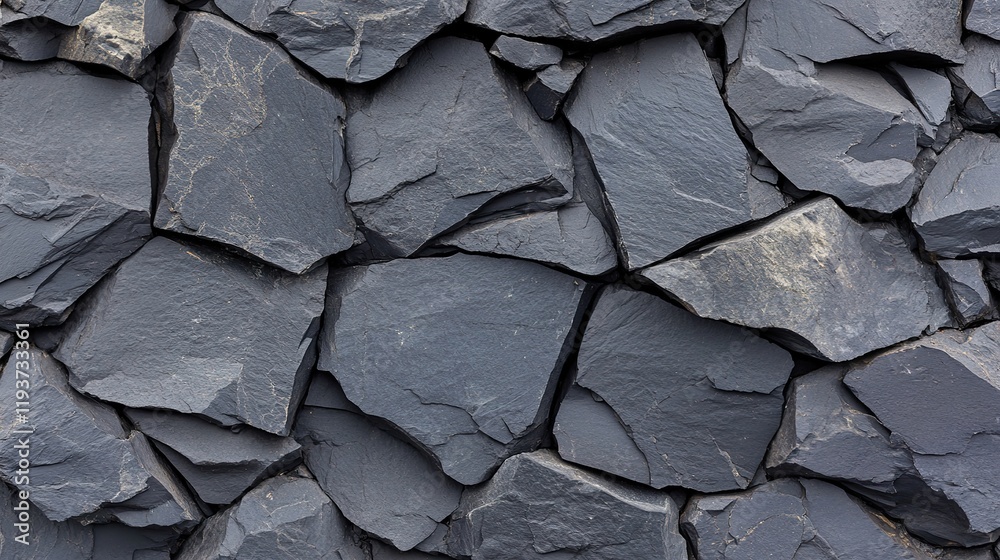 Close up of dark gray stone wall with irregular shapes and rough texture Close up of dark gray stone wall with irregular shapes and rough texture
