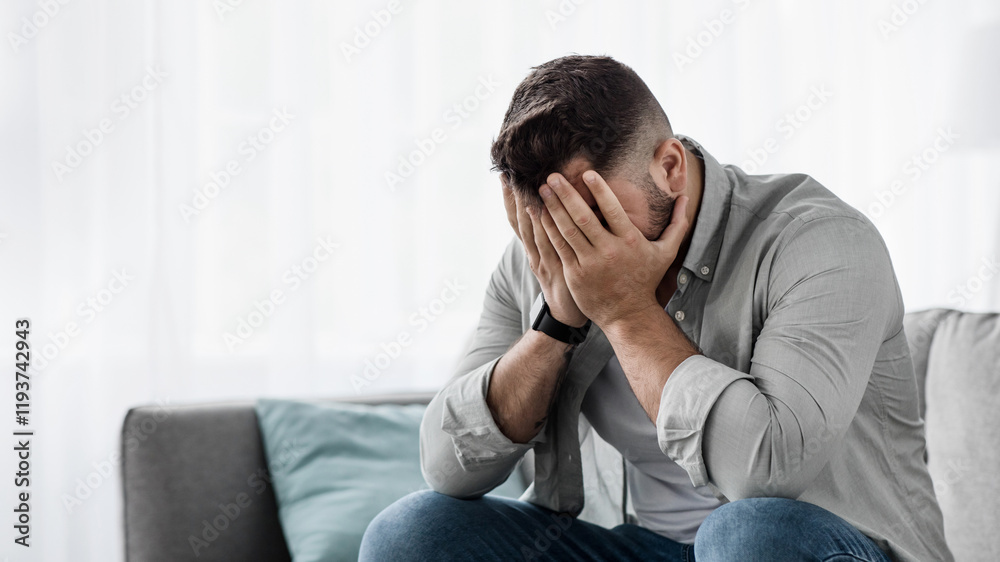 Shame despair, portrait of sad man suffers from headache, stress, depression. Failure unhappy millennial european handsome guy crying, covering face with hands, sit on sofa in living room interior Shame despair, portrait of sad man suffers from headache, stress, depression. Failure unhappy millennial european handsome guy crying, covering face with hands, sit on sofa in living room interior