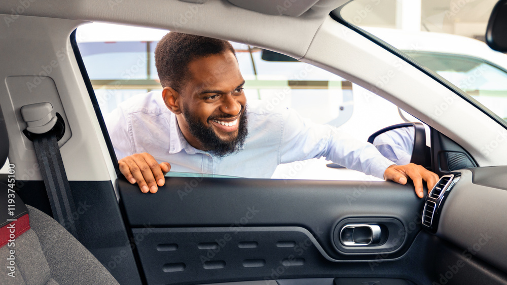 Smiling Black Man Choosing New Vehicle, Looking Inside Of Car With Excitement, Happy Male Buyer Checking Interior And Auto Characteristics While Spending Time In Dealership Center, Closeup Smiling Black Man Choosing New Vehicle, Looking Inside Of Car With Excitement, Happy Male Buyer Checking Interior And Auto Characteristics While Spending Time In Dealership Center, Closeup