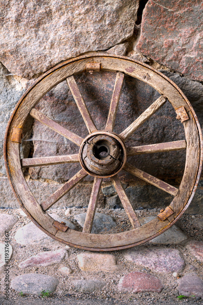 Old wooden wheel against the wall. Village life. Old wooden wheel against the wall. Village life.