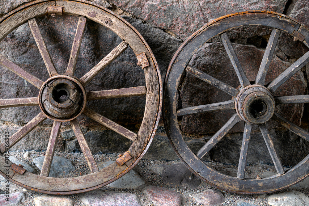 Old wooden cart wheels against the wall. Village life. Old wooden cart wheels against the wall. Village life.