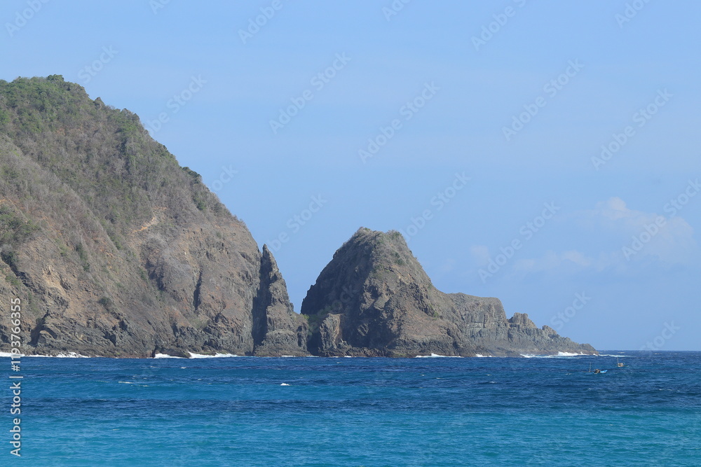 Coastal Cliffs Meet Turquoise Ocean Waves Crashing Gently on Rocky Shores with Distant Boat Sailing Peacefully. Coastal Cliffs Meet Turquoise Ocean Waves Crashing Gently on Rocky Shores with Distant Boat Sailing Peacefully.