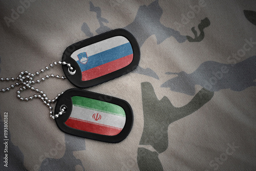 vintage army blank, dog tag with flag of slovenia and iran on the khaki texture background. military concept. photo