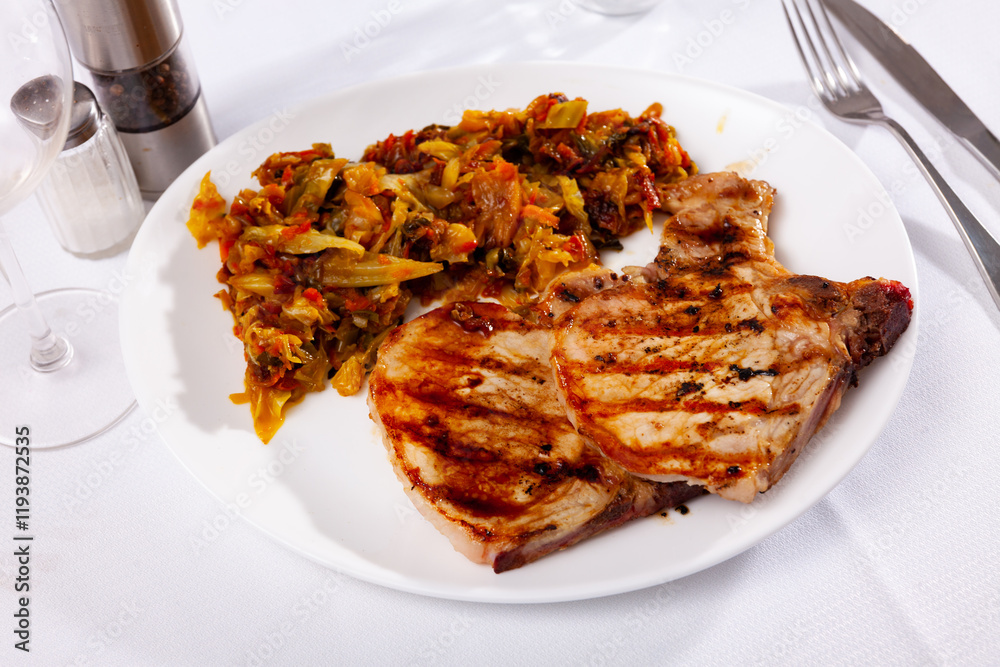 Portion of pork meat with stewed cabbage served on plate. Portion of pork meat with stewed cabbage served on plate.