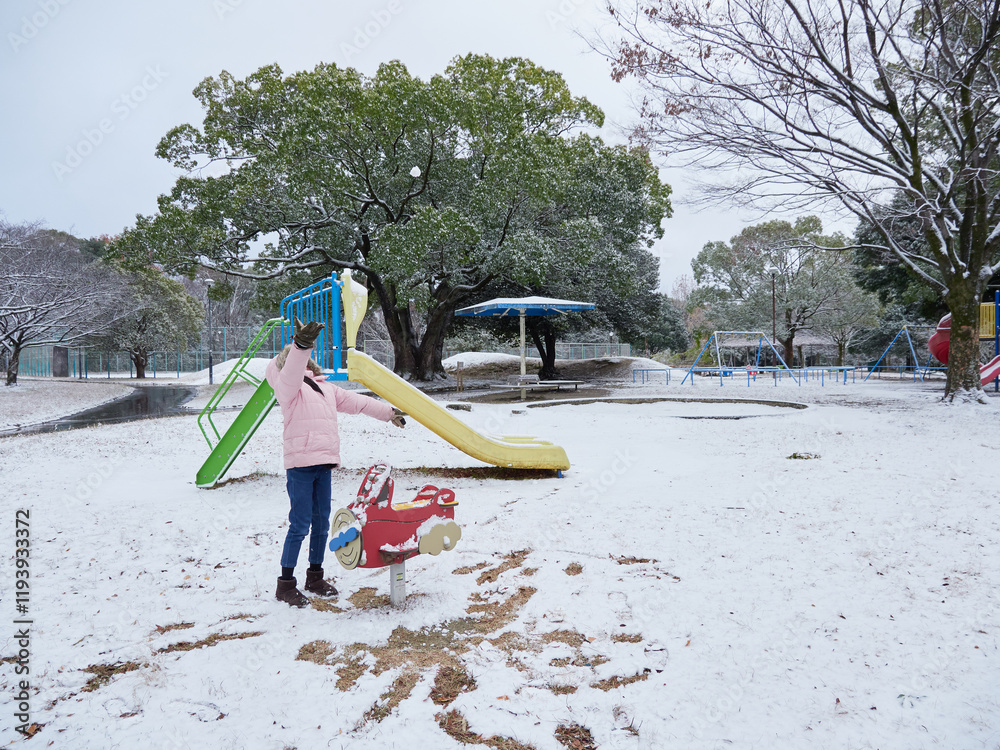 Φωτογραφία 冬の公園で楽しく雪遊びしている小学生の女の子の様子