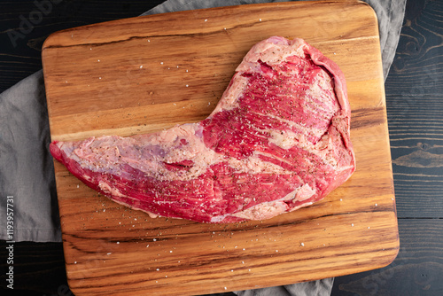 Raw TRi-Tip Sprinkled with Kosher Salt and Black Pepper: Uncooked beef tritip on wooden cutting board seasoned with coarse salt and ground pepper photo