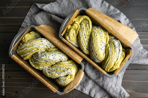 Matcha Black Sesame Babka Dough in Loaf Pans: Filled and twisted bread dough in two parchment lined loaf pans after second rise photo