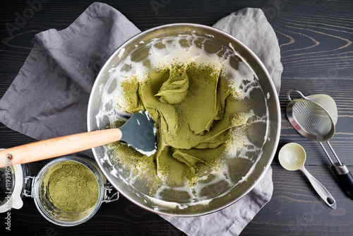 Matcha Sprinkled Over Whipped Cream Cheese: Green tea powder sifted into beaten cream cheese in a metal mixing bowl with spatula photo