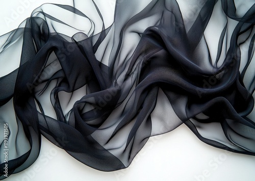 A flowing black fabric drapes gracefully, showcasing its sheer texture and soft folds, perfect for fashion or decoration.