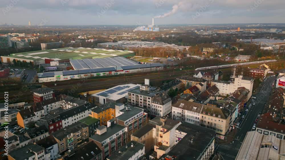 Drone shot capturing the railway lines weaving through industrial and residential areas in Oberhausen, Germany, reflecting a dynamic mix of commerce, transport, and urban planning. Drone shot capturing the railway lines weaving through industrial and residential areas in Oberhausen, Germany, reflecting a dynamic mix of commerce, transport, and urban planning.
