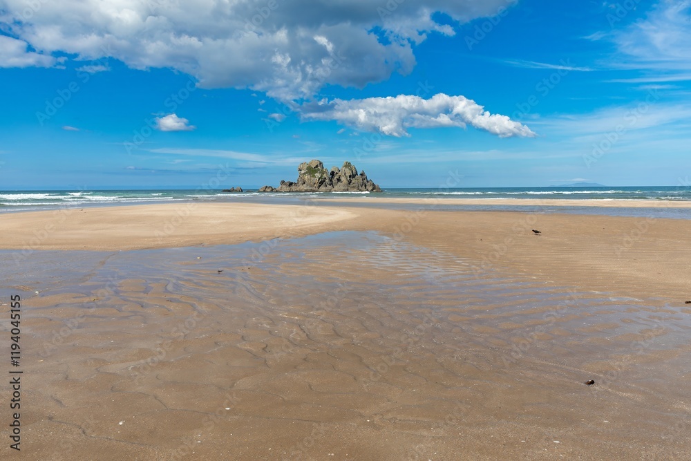 Tranquil beach scene with low tide, rocky outcrop, and a lone bird. Coastal beauty on a sunny day. Opoutere, Whangamata, Coromandel Peninsula, New Zealand Tranquil beach scene with low tide, rocky outcrop, and a lone bird. Coastal beauty on a sunny day. Opoutere, Whangamata, Coromandel Peninsula, New Zealand