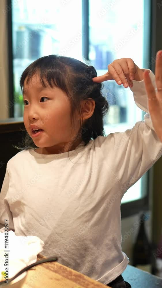 A Japanese woman in her 30s, a 6-year-old woman, and a man in his 20s are having dinner at an izakaya. Vertical video. A Japanese woman in her 30s, a 6-year-old woman, and a man in his 20s are having dinner at an izakaya. Vertical video.