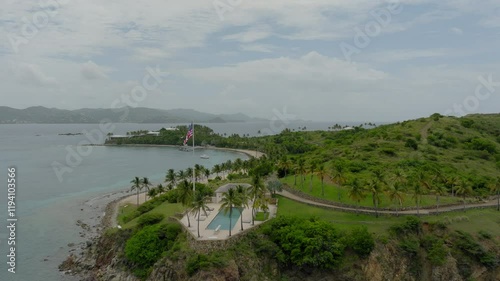 Wallpaper Mural Aerial Shot Of National Flag Outside Villa On Tranquil Island, Drone Flying Backwards Over Sea - VI, 
Little Saint James, United States of America Torontodigital.ca