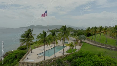 Aerial: Drone Panning Shot Of National Flagpole Outside Villa On Small Island - VI, 
Little Saint James, United States of America