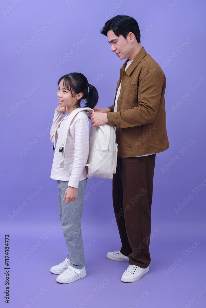 Young Asian father and daughter on purple background