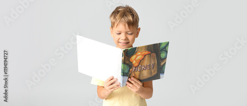 Cute little boy reading boo...